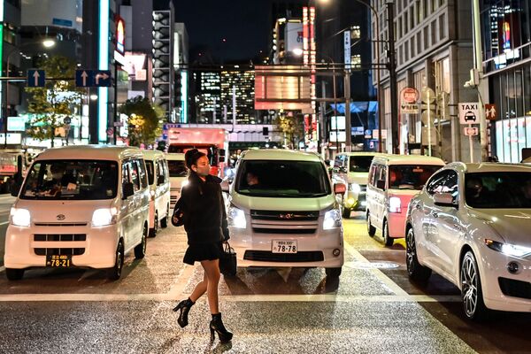 Женщина в защитной маске переходит дорогу в Токио. - Sputnik Узбекистан