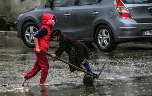 Палестинские дети в дождливый день в Рафахе на юге сектора Газа. - Sputnik Узбекистан
