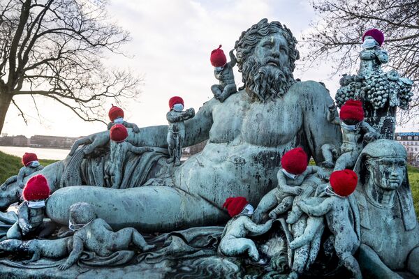 Маленькие бронзовые статуи в рождественских колпаках и масках в Копенгагене. - Sputnik Узбекистан