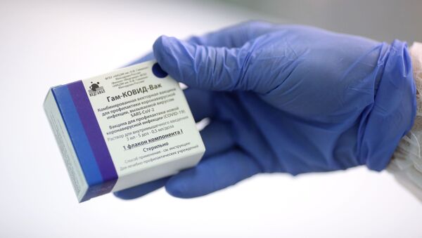 Медсестра держит в руках упаковку с вакциной от коронавируса Гам-Ковид-Вак - Sputnik Узбекистан