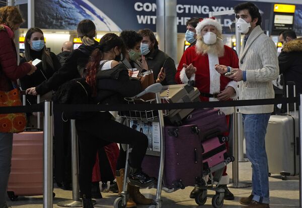 Turist v kostume Santa-Klausa v ocheredi v zale vileta terminala 2 aeroporta Xitrou v Londone, Velikobritaniya - Sputnik O‘zbekiston