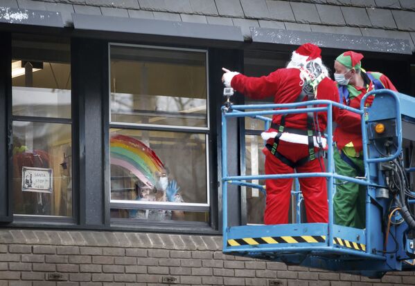 Мужчины в новогодних костюмах поддерживают пациентов детской больницы в Лидсе, Англия - Sputnik Ўзбекистон