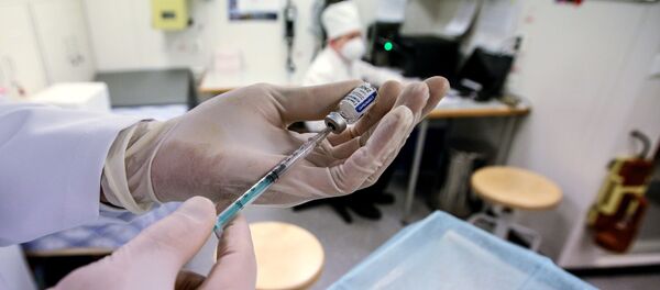 Медицинский работник набирает в шприц вакцину от COVID-19 - Sputnik Узбекистан