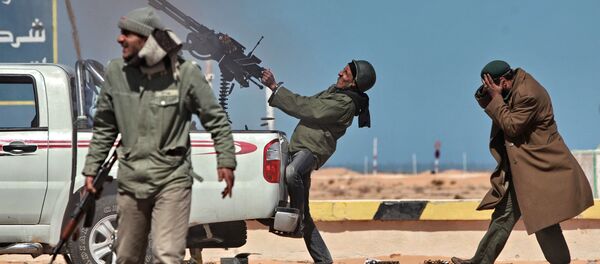 Боец оппозиции стреляет из пулемета в истребитель в городе Рас-Лануф - Sputnik Узбекистан