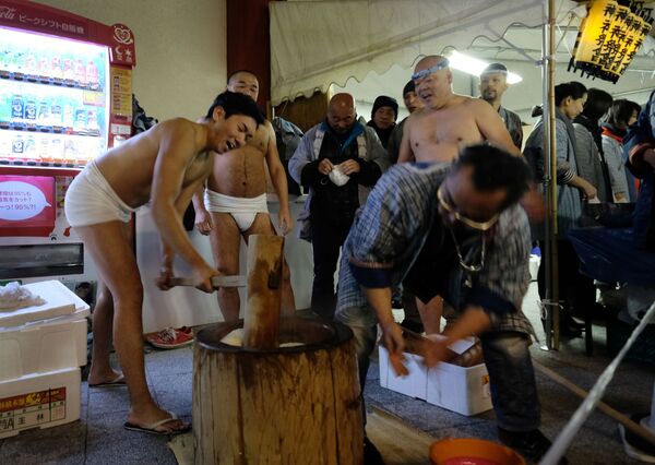 Японские мужчины толкут вареный рис для пирога моти в рамках празднования Нового года в Токио - Sputnik Узбекистан