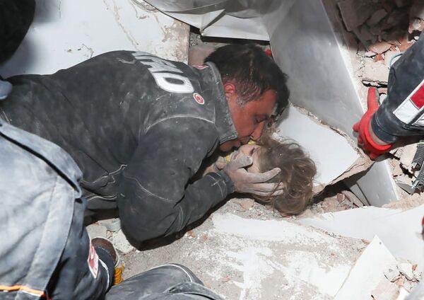Турецкие спасатели вытаскивают ребенка из под обломков после землетрясения в Измире - Sputnik Узбекистан