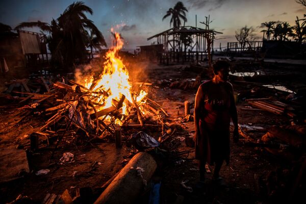 Люди сжигают мусор, оставшийся после урагана Йота в Бильви, Никарагуа - Sputnik Узбекистан