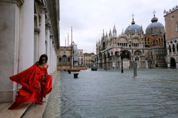 Женщина в развевающемся платье на затопленной площади Сан-Марко в Венеции, Италия - Sputnik Узбекистан