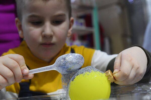 Мальчик на мастер-классе по декорированию стеклянного шара в салоне-галерее ёлочных игрушек в павильоне №519 на ВДНХ. - Sputnik Узбекистан
