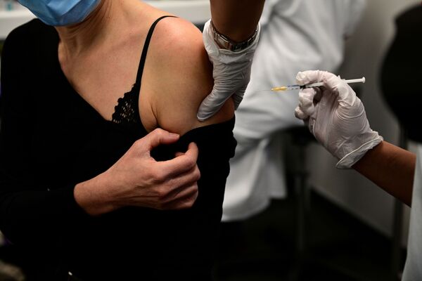 Женщина в Париже получает вакцину от коронавируса.  - Sputnik Узбекистан