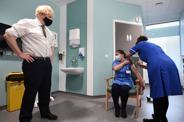 Премьер-министр Великобритании Борис Джонсон наблюдает за вакцинацией во время своего визита в больницу Chase Farm на севере Лондона - Sputnik Ўзбекистон