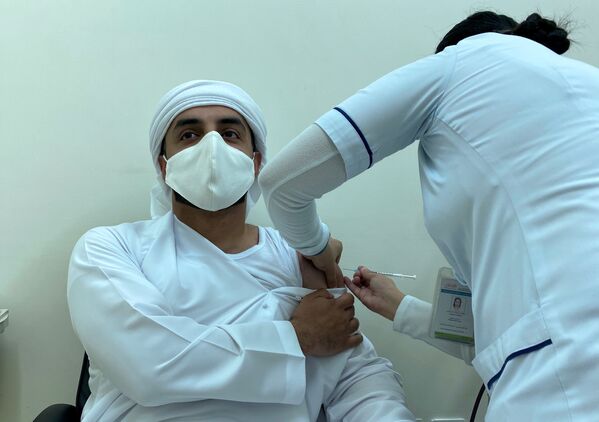 Мужчина получает дозу вакцины против COVID-19 в Дубае, ОАЭ. - Sputnik Узбекистан