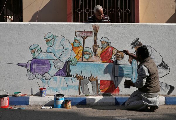 Мужчина рисует граффити, изображающее вакцину от COVID-19, в Калькутте, Индия - Sputnik Ўзбекистон