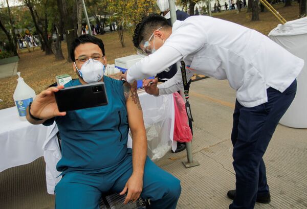 Медработник делает селфи во время вакцинации от COVID-19 в военном госпитале в Сан-Николас-де-лос-Гарса, Мексика. - Sputnik Узбекистан