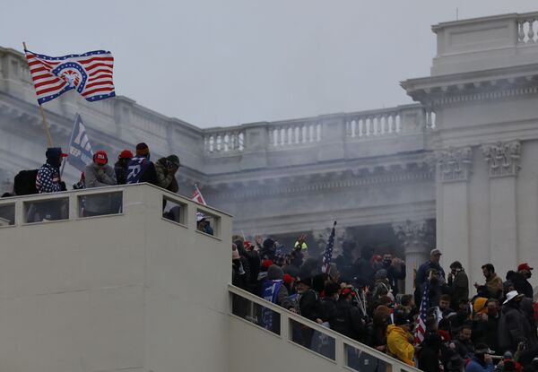 Митингующие в клубе дыма на лестнице Капитолия в Вашингтоне. - Sputnik Узбекистан