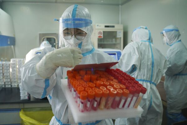Китайский медработник с пробирками в лаборатории. - Sputnik Узбекистан