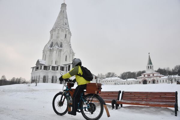 Молодой человек на велосипеде около церкви Вознесения Господня в парке Коломенское в Москве. - Sputnik Узбекистан