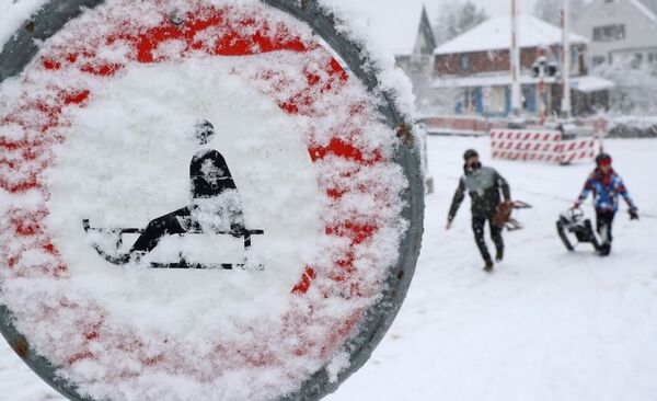 Люди на санках во время снегопада в Цюрихе. - Sputnik Узбекистан