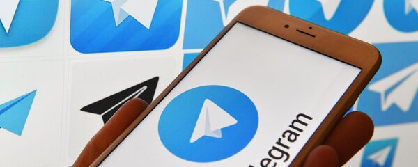 Логотип мессенджера Telegram на экранах смартфона и компьютера Логотип мессенджера Telegram на экранах смартфона и компьютера - Sputnik Узбекистан