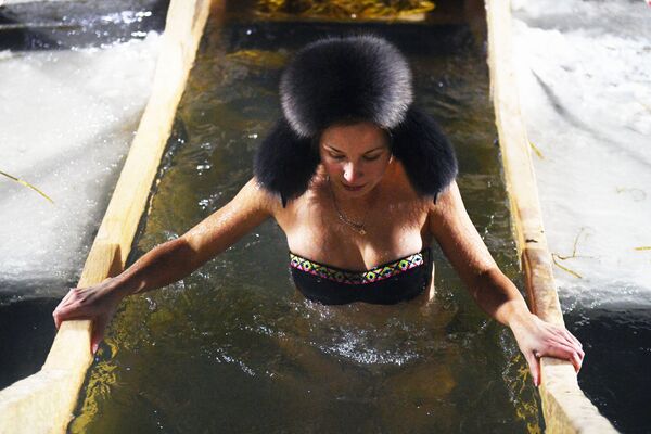 Девушка во время крещенского купания в проруби на реке Обь в черте Новосибирска - Sputnik Узбекистан