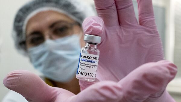 Медработник демонстрирует компонент 1 вакцины от коронавируса Спутник V в прививочном пункте городской поликлиники  - Sputnik Ўзбекистон