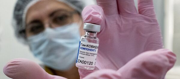 Медработник демонстрирует компонент 1 вакцины от коронавируса Спутник V в прививочном пункте городской поликлиники  - Sputnik Ўзбекистон