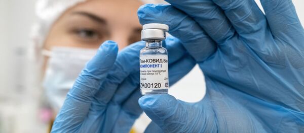 Медработник демонстрирует компонент 1 вакцины от коронавируса Спутник V в прививочном пункте городской поликлиники  - Sputnik Ўзбекистон