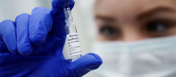 Медработник демонстрирует вакцину ЭпиВакКорона в процедурном кабинете - Sputnik Ўзбекистон