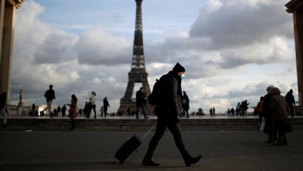Мужчина в защитной маске гуляет по площади Трокадеро возле Эйфелевой башни в Париже - Sputnik Узбекистан