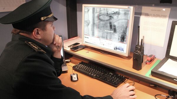 Работник таможенной службы проводит осмотр груза на экране монитора - Sputnik Узбекистан