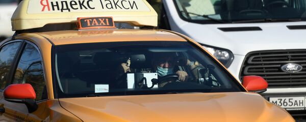Водитель в защитной маске за рулем такси - Sputnik Узбекистан