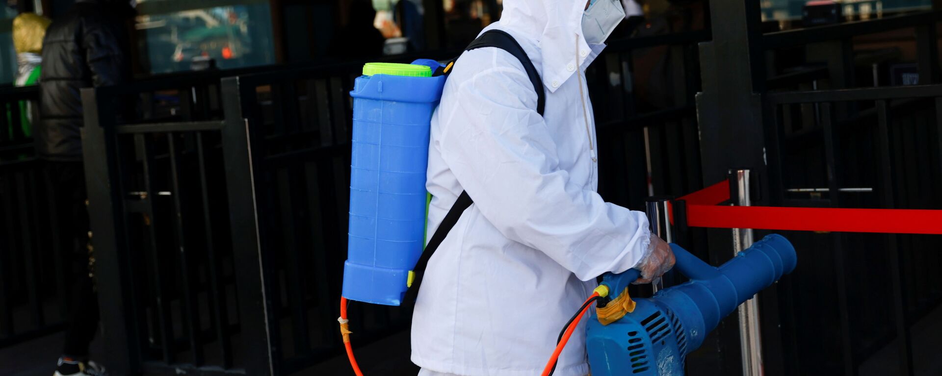 Работник в защитном костюме во время дезинфекции вокзала в Пекине, Китай - Sputnik Ўзбекистон, 1920, 10.11.2021