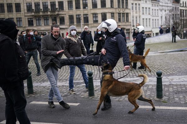 Полицейский бьет демонстранта во время несанкционированной демонстрации против ограничительных мер COVID-19 в Брюсселе. - Sputnik Узбекистан