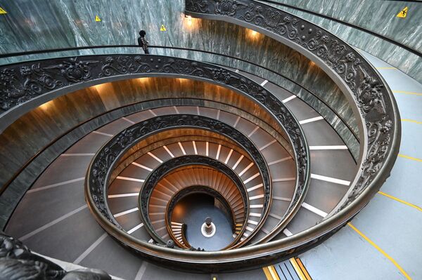 Мужчина спускается по лестнице Браманте в музее Ватикана. - Sputnik Узбекистан