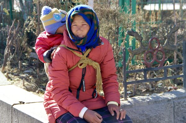 Женщина с ребенком на одной из улиц города Лхаса в Тибете. - Sputnik Узбекистан