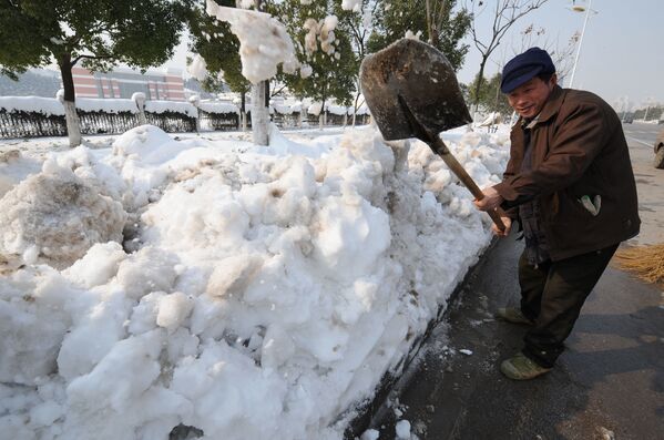 Китайский рабочий чистит улицы от сильного снегопада в Китае, 2008 год. - Sputnik Узбекистан