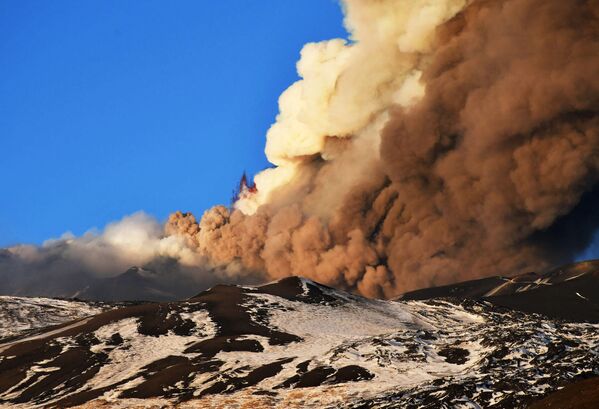 Во время впечатляющего извержения и сильной взрывной активности из юго-восточного кратера Этна выбросил высокое облако лавового пепла, которое рассеивалось в направлении юга. - Sputnik Узбекистан