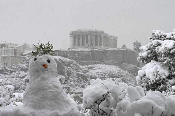 Снеговик на фоне заснеженного Парфенона в Афинах. - Sputnik Узбекистан