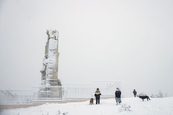 Люди поднимаются на холм Филопаппу во время сильного снегопада в Афинах, Греция - Sputnik Узбекистан