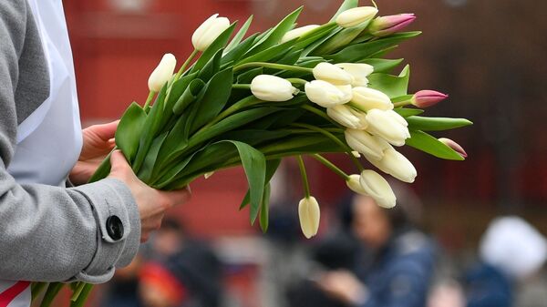 Тюльпаны в руках участника всероссийской акции Вам, любимые! в Москве - Sputnik Узбекистан