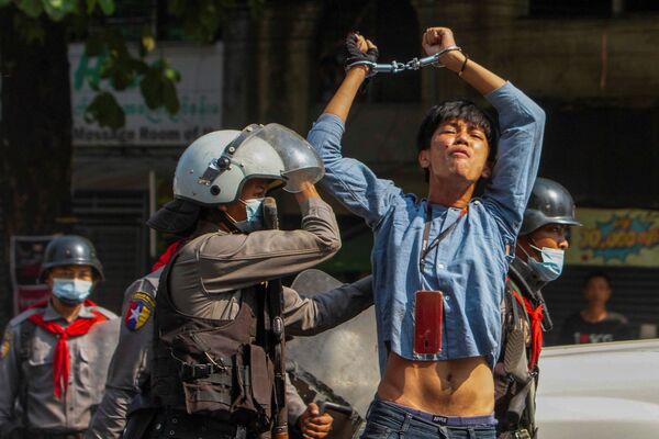 Myanma, Yangon shahrida harbiy to‘ntarishga qarshi miting paytida politsiya xodimlari tomonidan hibsga olingan namoyishchi - Sputnik O‘zbekiston