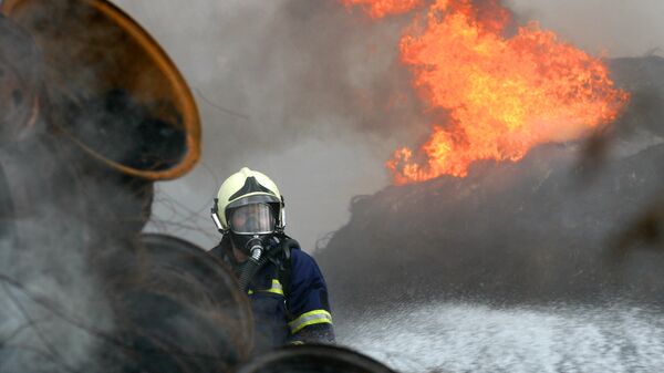 Пожарный тушит горящие шины - Sputnik Узбекистан