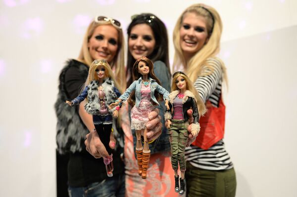 Модели позируют с куклами Барби, одетыми в похожие наряды, на стенде Mattel на Международной выставке игрушек в Нюрнберге. - Sputnik Узбекистан