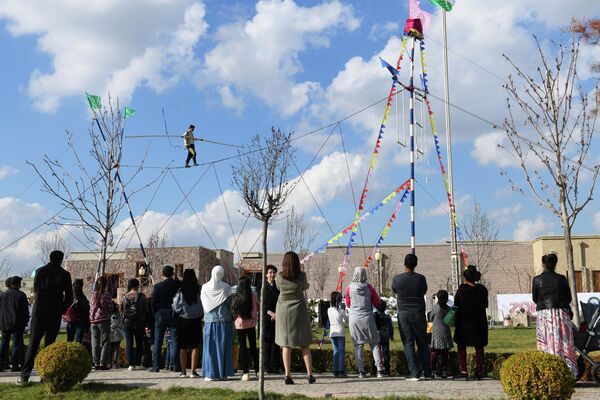 А на площадке рядом посетители наблюдают за канатоходцем. - Sputnik Узбекистан