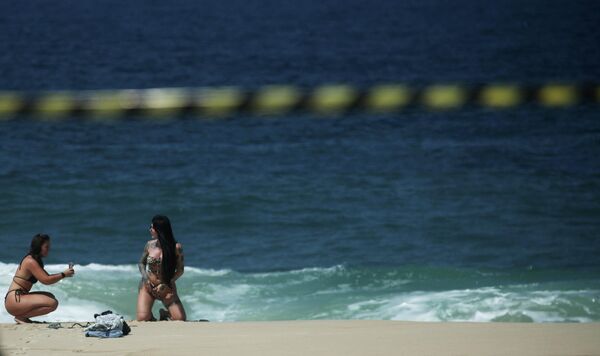 Девушка позирует на пустом пляже Ипанема после того, как в рамках  ограничительных мер по сдерживанию вспышки коронавирусной болезни закрылись все пляжи в Рио-де-Жанейро, Бразилия.REUTERS/Ricardo Moraes - Sputnik Узбекистан