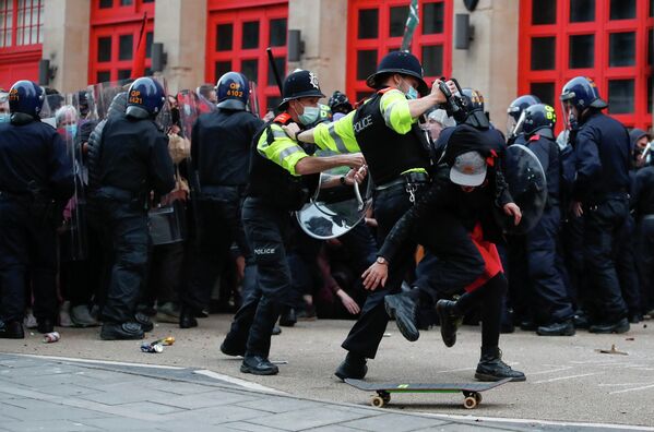 Полицейские пытаются задержать демонстранта во время акции протеста против нового законопроекта о полиции в Бристоле, Великобритания, 21 марта, 2021 года. REUTERS/Peter Cziborra - Sputnik Узбекистан