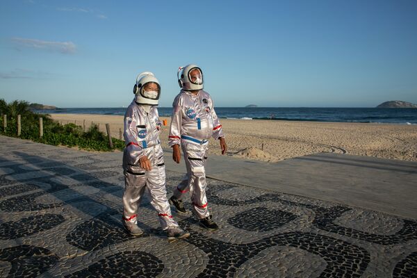 Влюбленные гуляют по пляжу Ипанема в костюмах космонавтов. Они считают, что такая одежда - лучшая защита от коронавируса. - Sputnik Узбекистан