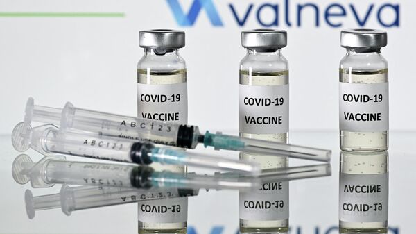 Шприцы и пузырьки с вакциной на фоне логотипа компании Valneva - Sputnik Узбекистан