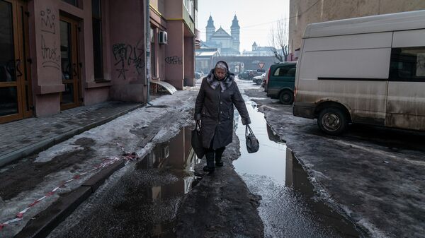 Женщина идет по улице в Ивано-Франковске, Украина - Sputnik Узбекистан