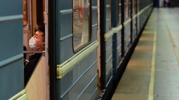 Пассажир в медицинской маске в вагоне поезда - Sputnik Узбекистан